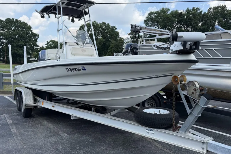 Slide: The Image of 2003 Triton 220 LTS boat on trailer, parked outdoors under cloudy sky. - 1