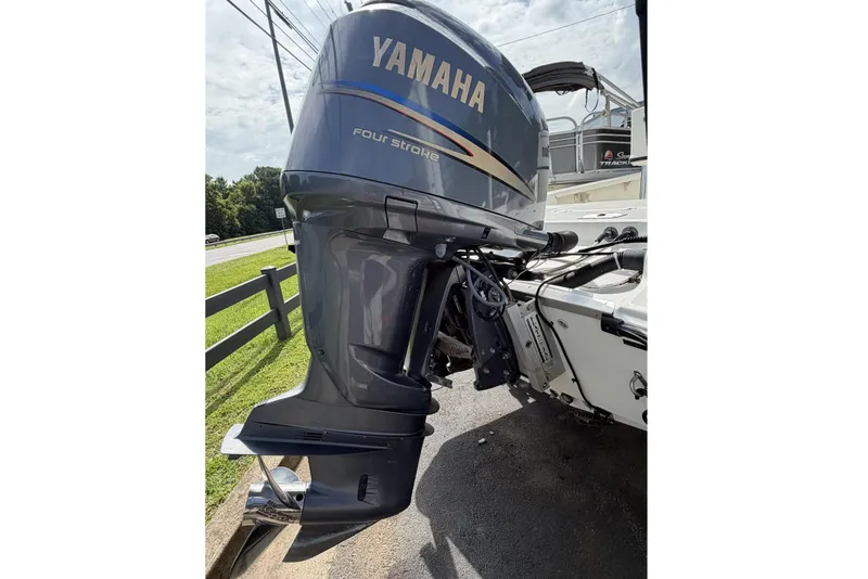 Slide: The Image of Yamaha four-stroke outboard motor on a 2003 Triton 220 LTS boat, parked outdoors. - 8