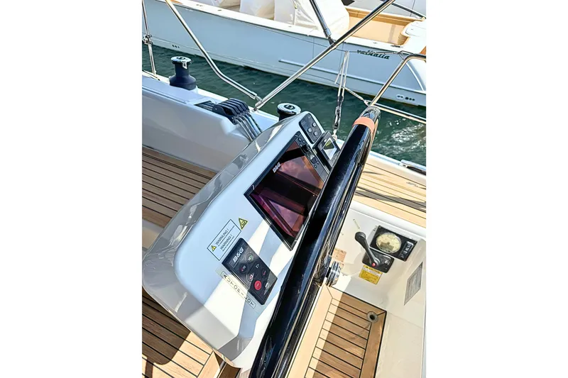 Slide: The Image of Steering console of a 2020 Hanse 458 yacht with navigation controls and wooden deck. - 9
