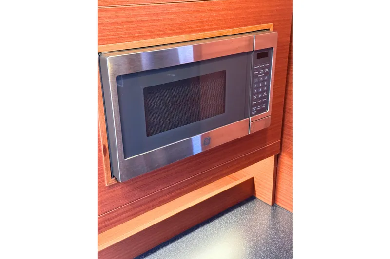 Slide: The Image of Built-in microwave in a 2020 Hanse 458 yacht's wooden kitchen interior. - 21