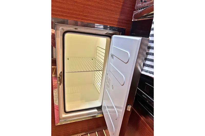 Slide: The Image of Open refrigerator in 2020 Hanse 458 yacht interior, showcasing empty shelves. - 20