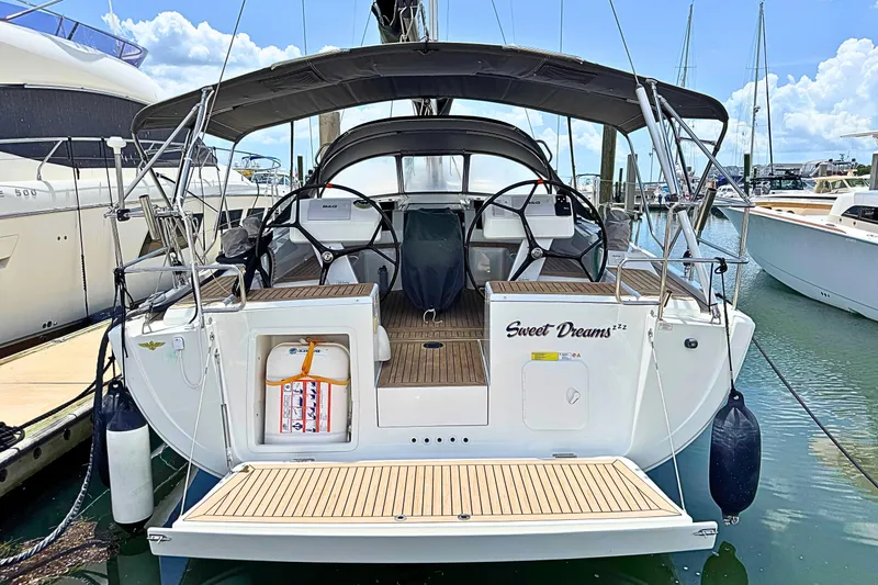 Slide: The Image of 2020 Hanse 458 sailboat docked, featuring spacious deck and dual steering wheels. - 13