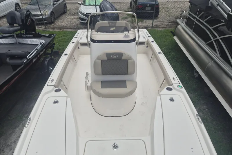 Slide: The Image of 2026 Key West 210 Bay Reef boat with beige seating, parked among other boats. - 19