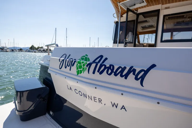 Slide: The Image of 2021 Cutwater C-32 Coupe boat docked in La Conner, WA, with "Hop Aboard" text. - 2