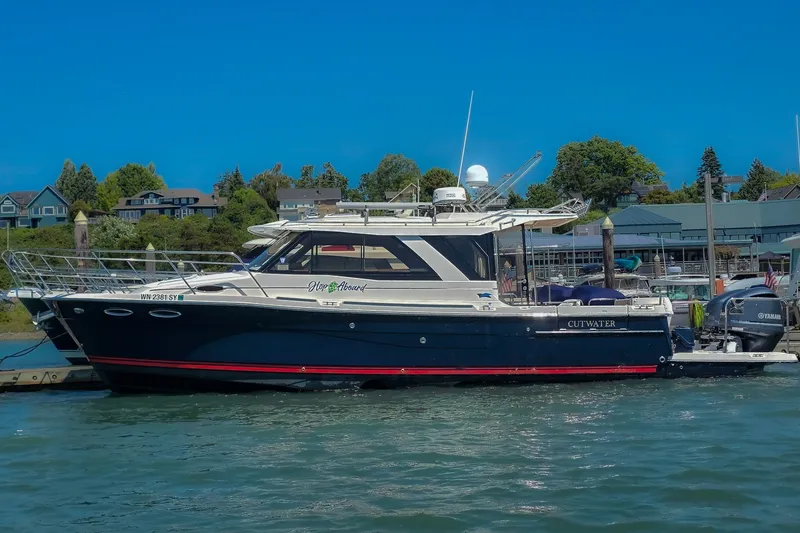 The Image of 2021 Cutwater C-32 Coupe boat docked in a scenic marina setting. - 0
