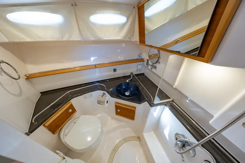 Slide: The Image of 2021 Cutwater C-32 Coupe bathroom with modern fixtures, compact design, and elegant wood accents. - 21