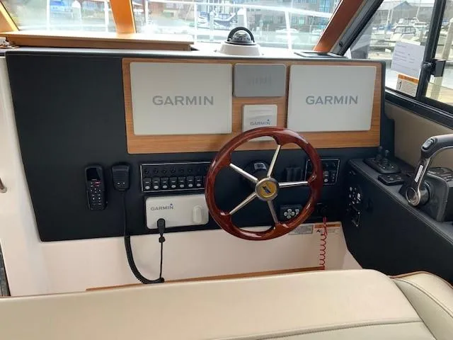 Slide: The Image of The 2021 Cutwater C-32 Coupe cockpit features a sleek steering wheel and Garmin electronics. - 14