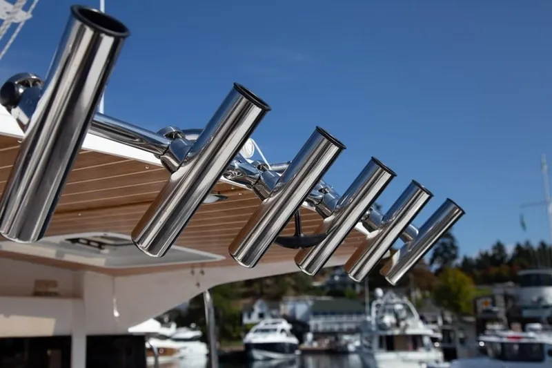 Slide: The Image of Close-up of fishing rod holders on a boat, with a marina in the background. - 10