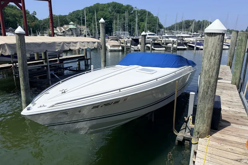 Slide: The Image of 1995 Formula 303 SR-1 boat docked at marina with blue cover. - 2