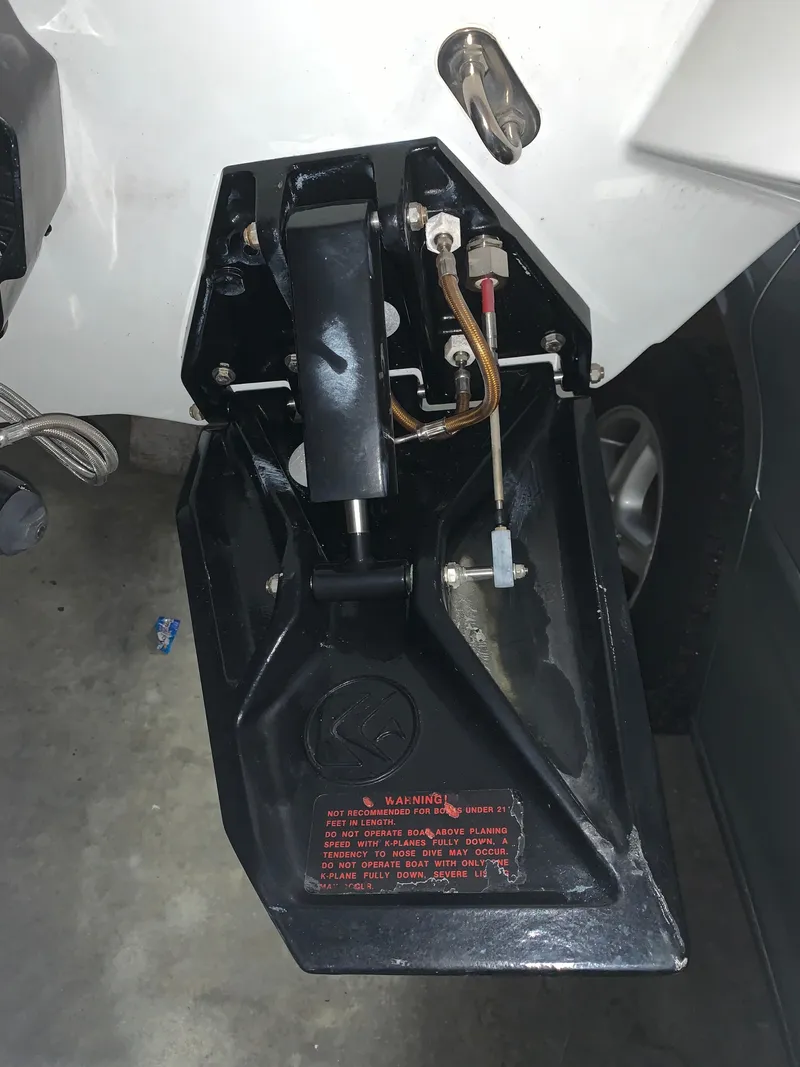 Slide: The Image of Close-up of a boat's stern drive with hydraulic lines and warning labels. - 34