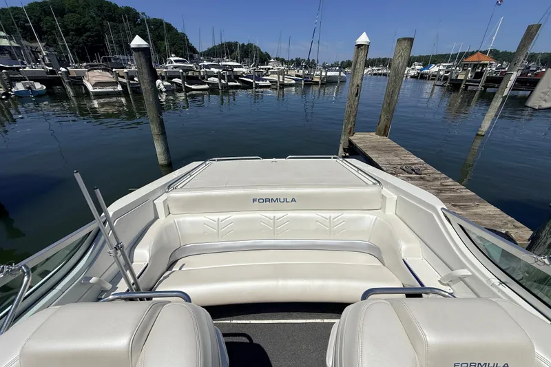 Slide: The Image of 1995 Formula 303 SR-1 boat interior at marina, showcasing white seating and docked boats. - 20
