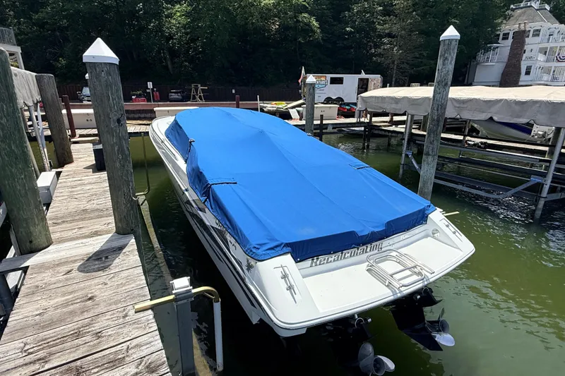 Slide: The Image of 1995 Formula 303 SR-1 boat docked with blue cover, surrounded by wooden piers. - 4