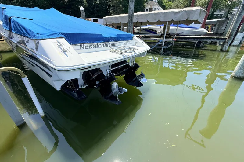 Slide: The Image of 1995 Formula 303 SR-1 boat docked with blue cover, rear view. - 5