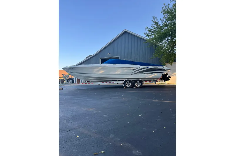 Slide: The Image of 1995 Formula 303 SR-1 boat on trailer, parked near a large building. - 7