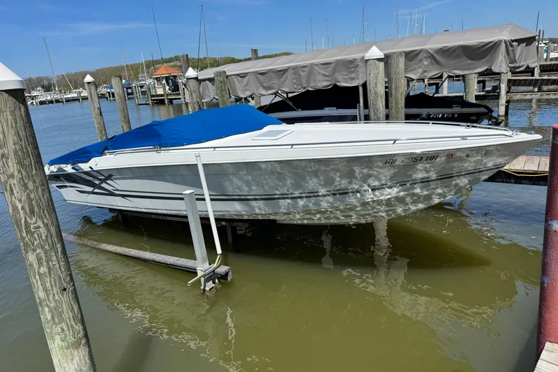 Slide: The Image of 1995 Formula 303 SR-1 boat docked with blue cover at marina. - 10