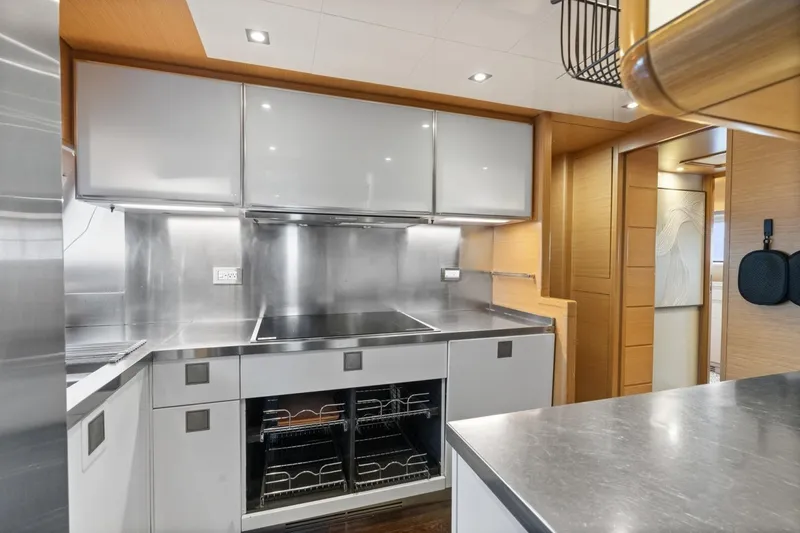 Slide: The Image of Modern kitchen interior on 2011 Ferretti Yachts 97, featuring sleek cabinetry and stainless steel surfaces. - 23