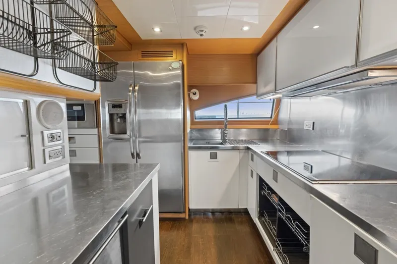 Slide: The Image of Modern kitchen interior on 2011 Ferretti Yachts 97, featuring stainless steel appliances and sleek design. - 24