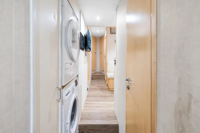 Slide: The Image of Hallway inside 2011 Ferretti Yachts 97, featuring laundry appliances and modern wood finishes. - 42