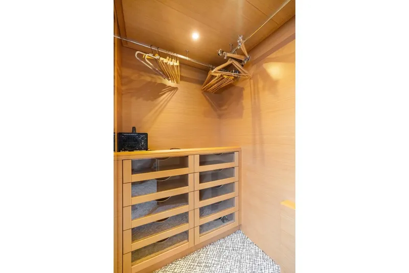 Slide: The Image of Luxurious wooden closet interior on a 2011 Ferretti Yachts 97, featuring hangers and drawers. - 30