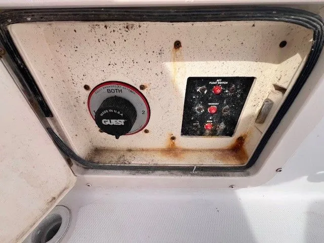 Slide: The Image of An electrical panel with switches and a rotary switch in a Grady-White 225 Express boat. - 18