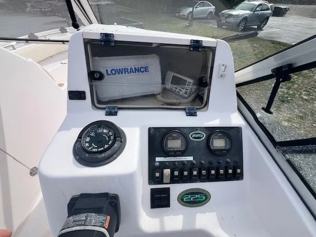 The Image of The image shows the helm of a 2003 Grady-White 225 Express boat with instruments and switches. - 1