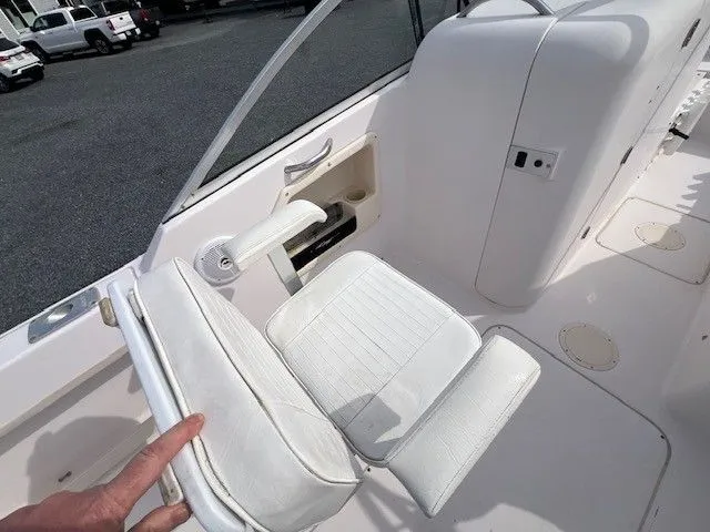 Slide: The Image of A white seat on a boat with armrests and a small storage compartment beside it. - 26