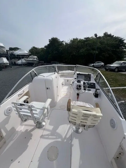 Slide: The Image of The image shows a 2003 Grady-White 225 Express boat with an open cockpit and helm station. - 17