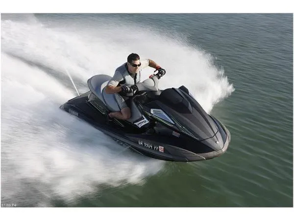Slide: The Image of A man rides a black 2009 Yamaha FX® SHO jet ski on the water. - 2