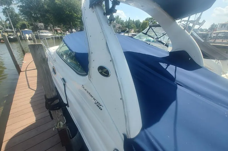Slide: The Image of 2008 Sea Ray Sundancer 280 docked, featuring blue cover and sleek design. - 5