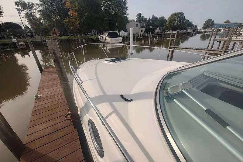 Slide: The Image of 2009 Sea Ray Sundancer 280 docked at a marina, showcasing sleek design and calm waters. - 18