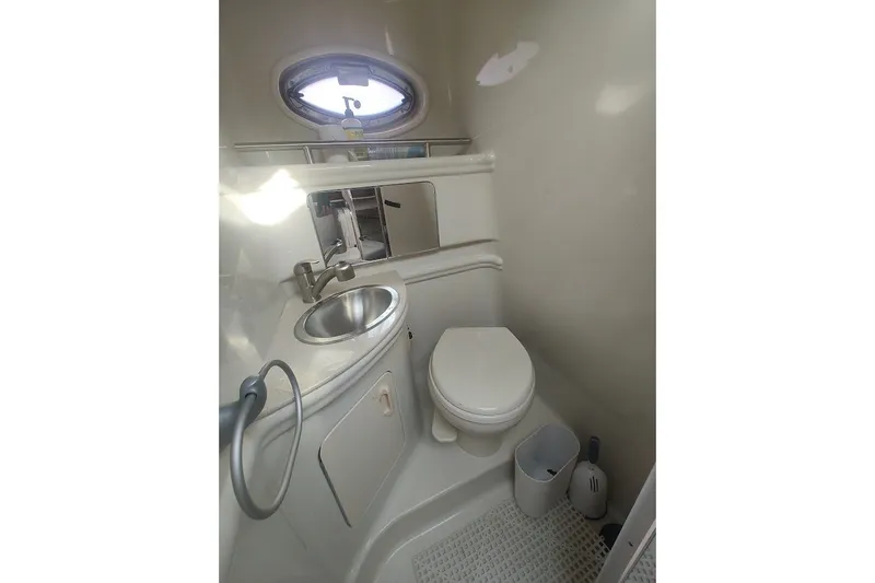 Slide: The Image of 2009 Sea Ray Sundancer 280 bathroom with sink, toilet, and porthole window. - 29