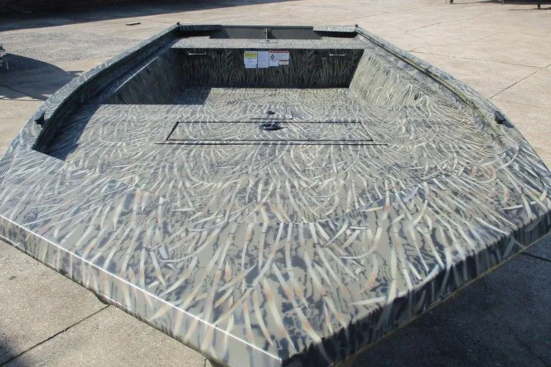 Slide: The Image of 2027 Tracker Grizzly 1648 boat with camouflage pattern on concrete surface. - 3