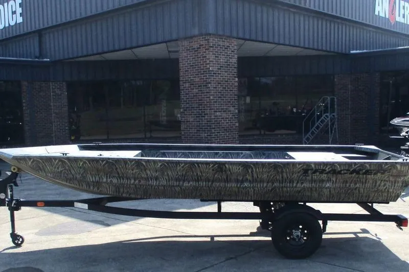 The Image of 2027 Tracker Grizzly 1648 boat on trailer outside a brick building. - 0