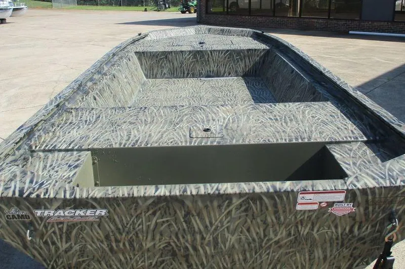 Slide: The Image of 2027 Tracker Grizzly 1648 boat with camo design, parked outdoors on concrete surface. - 2