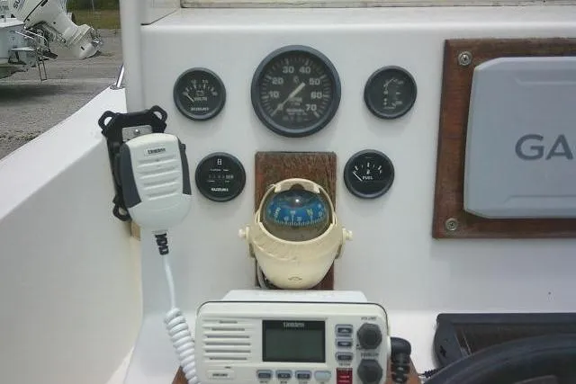 Slide: The Image of Dashboard of a 2008 C-Dory 22' Angler with gauges, compass, and communication equipment. - 24