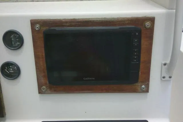 Slide: The Image of Dashboard of a 2008 C-Dory 22' Angler featuring a Garmin display and gauges. - 23