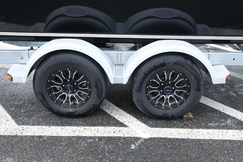 Slide: The Image of Trailer wheels of a 2022 Hewescraft 210 Sea Runner ET Hardtop on wet pavement. - 24