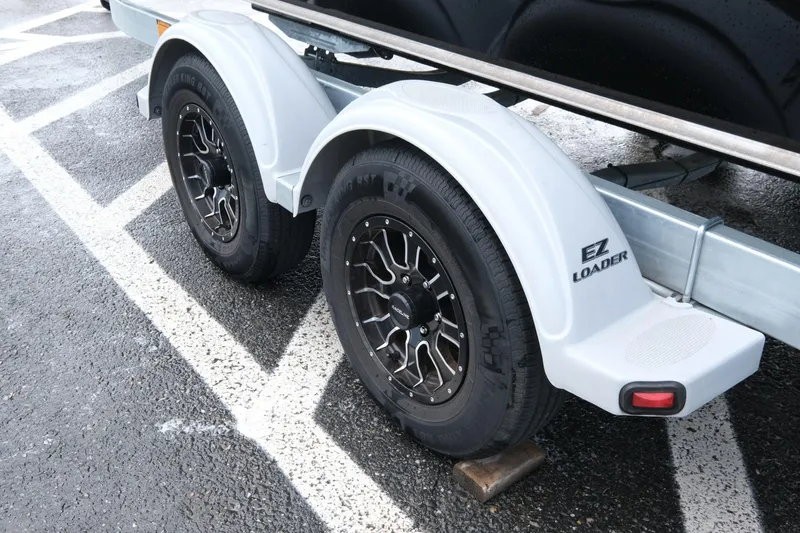 Slide: The Image of Trailer wheels of a 2022 Hewescraft 210 Sea Runner ET Hardtop on wet pavement. - 23