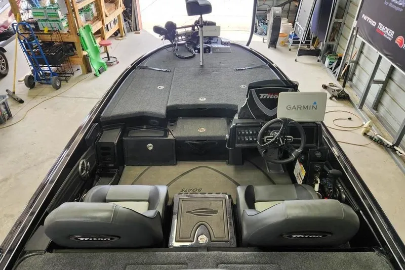 Slide: The Image of 2026 Triton 20XP boat interior with Garmin navigation system in a garage setting. - 2