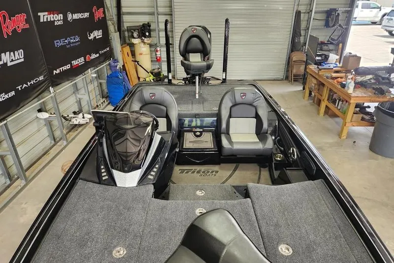 Slide: The Image of 2026 Triton 20XP boat interior in a garage, featuring seating and control panel. - 7