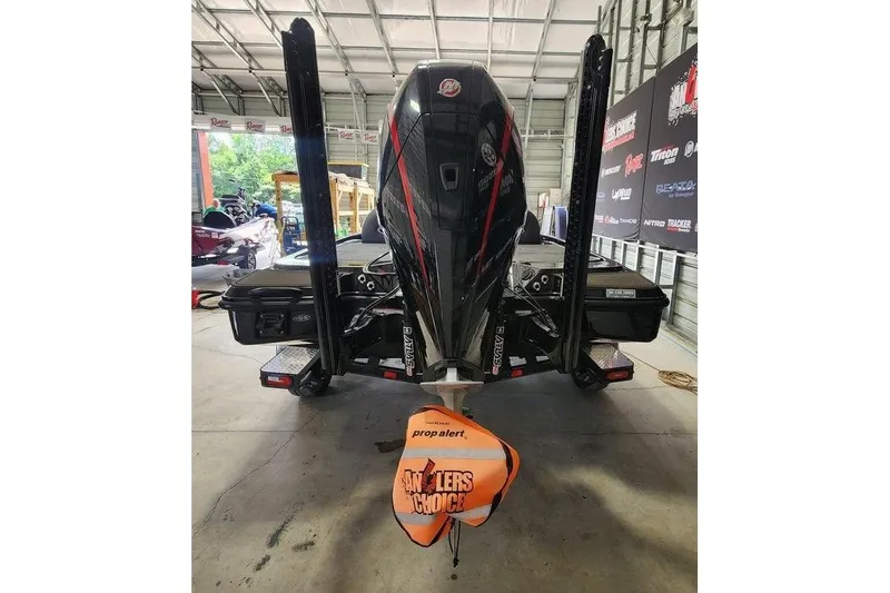 Slide: The Image of 2026 Triton 20XP boat in garage, rear view with motor and propeller cover. - 5