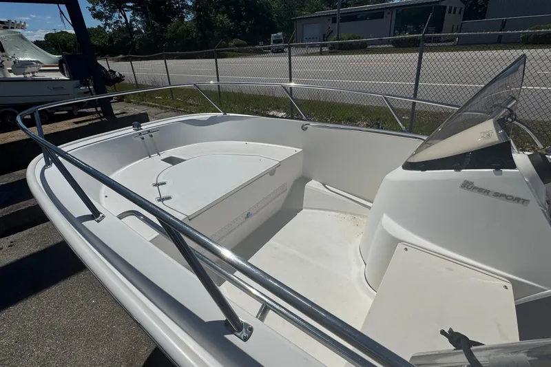Slide: The Image of 2014 Boston Whaler 150 Super Sport boat interior with seating and steering console. - 10