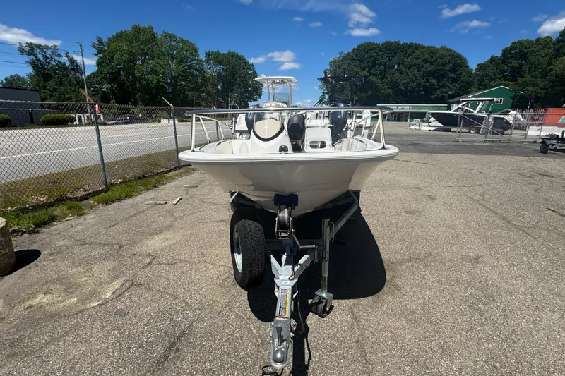 Slide: The Image of 2014 Boston Whaler 150 Super Sport boat on trailer, parked outdoors under clear blue sky. - 9