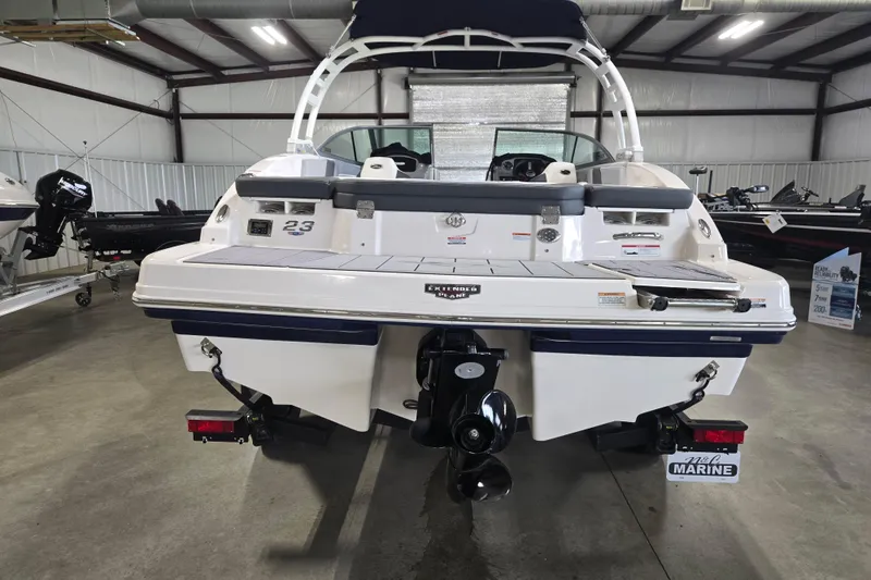 Slide: The Image of 2023 Chaparral 23 SSi boat in showroom, rear view showcasing sleek design and powerful engine. - 7