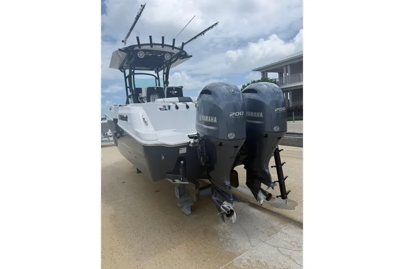 Slide: The Image of 2022 Wellcraft 262 Fisherman boat with dual Yamaha 200 engines, docked outdoors. - 3