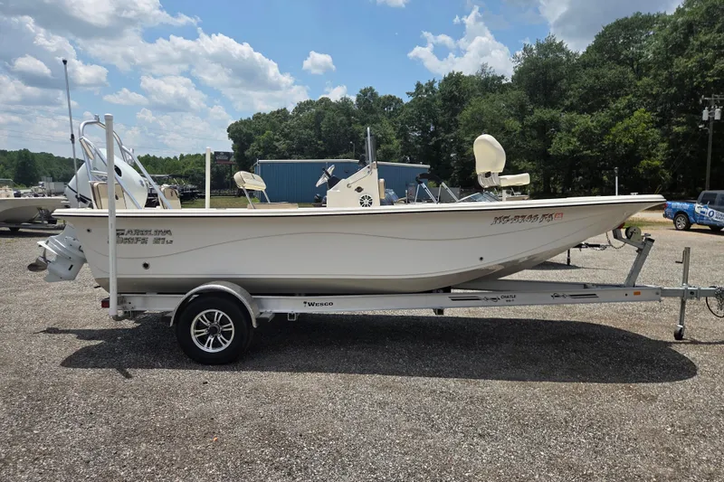 Slide: The Image of 2022 Carolina Skiff 21 LS boat on trailer, parked outdoors under a cloudy sky. - 5