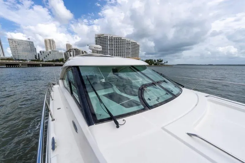Slide: The Image of 2009 Sea Ray 43 Sundancer yacht cruising near urban skyline under cloudy skies. - 55