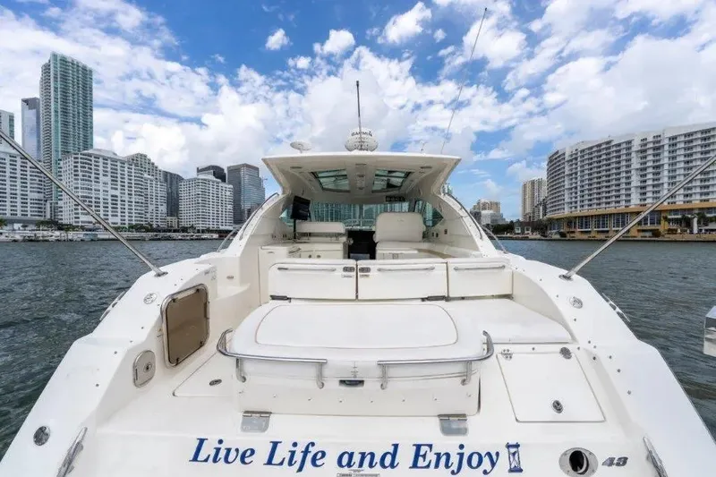 Slide: The Image of 2009 Sea Ray 43 Sundancer yacht docked with city skyline in background. - 43