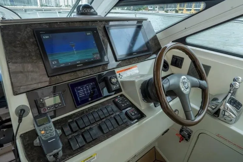 Slide: The Image of 2009 Sea Ray 43 Sundancer helm with navigation screens and steering wheel. - 49