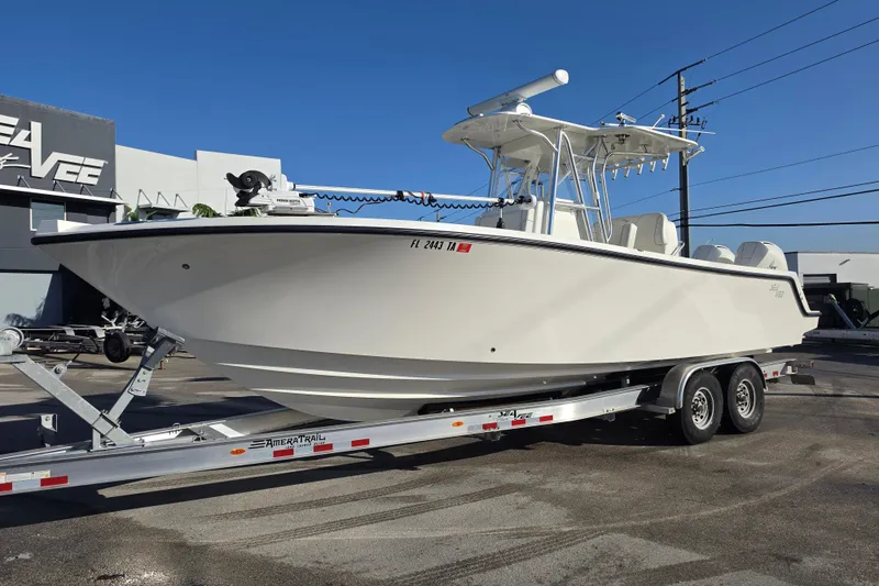 The Image of 2021 SeaVee 290B boat on trailer, parked outdoors under clear blue sky. - 1